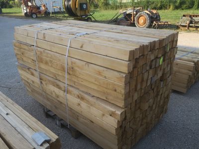 plusieurs morceaux de bois sont empilés sur un parking