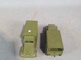 two green toy trucks sitting next to each other on a white surface