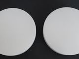 two round white plates on a black background