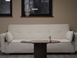 a white couch sitting in a living room next to two windows