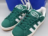 Chaussures adidas Superstar vertes et blanches, présentées dans une boîte bleue