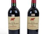 two bottles of red wine sitting next to each other on a white surface