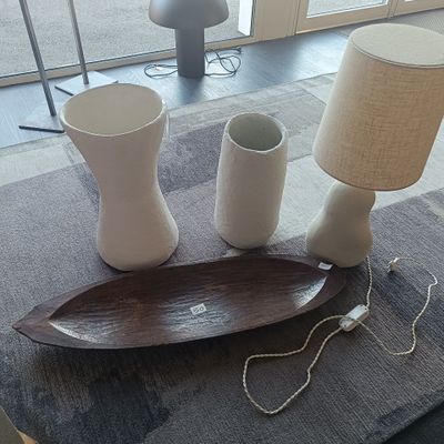 une table sur laquelle se trouvent une lampe, des vases et une assiette