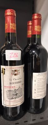 trois bouteilles de vin posées côte à côte sur une étagère