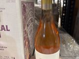 une bouteille de vin posée sur une table à côté d'une boîte