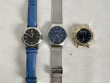 two watches and a watch on a white surface with a blue strap