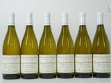 six bouteilles de vin blanc alignées sur une table