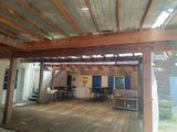a wooden deck with a table and chairs under a roof