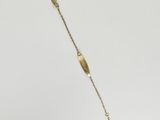 a gold necklace that has a gold bead on it