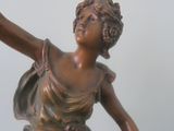 a bronze statue of a woman holding a basket of flowers