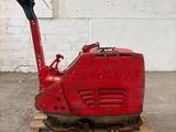 une machine rouge posée sur une palette dans un entrepôt
