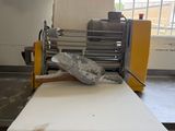 a machine that is cutting a sheet of paper on a table