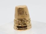 an image of a gold thimble sitting on top of a clear box