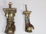 two brass objects on a white surface