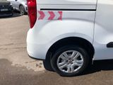 a white van parked in a parking lot with other cars in the background