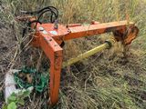 une charrue orange rouillée posée dans l'herbe