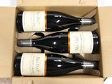 three bottles of wine are in a cardboard box on a table