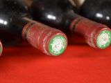 several bottles of wine are lined up on a red surface