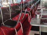 tables and chairs are lined up in a restaurant with pink walls
