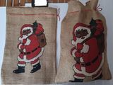deux sacs ornés d'un Père Noël, accrochés à un mur