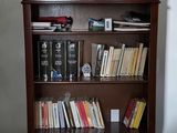 a bookshelf with a bunch of books on top of it