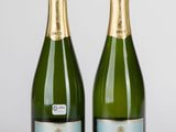 deux bouteilles de champagne posées l'une à côté de l'autre sur une table