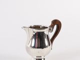 an antique silver coffee pot with a wooden handle on a white background