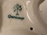 a white ceramic starfish with a green and white logo