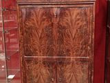 une armoire en bois comportant deux tiroirs et une vitrine en verre