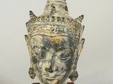 statue of a head of a woman with a crown on a wooden base