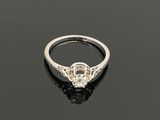 une bague en diamant et en or blanc sur un fond noir