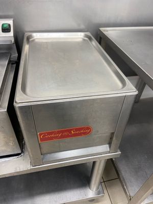 two stainless steel pans sitting on top of a metal counter