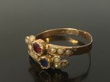 an image of a gold ring with red, blue and white stones