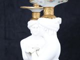 a white statue with a gold plate on top of it