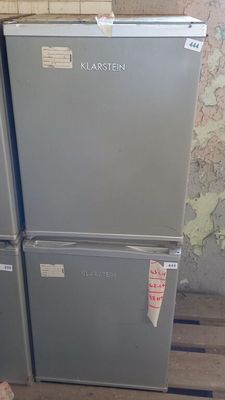 trois réfrigérateurs empilés sur des palettes dans une pièce