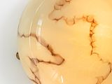 a white and brown marble ball on a white surface