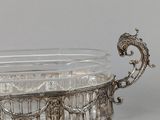 an antique silver plate with a glass bowl on a stand