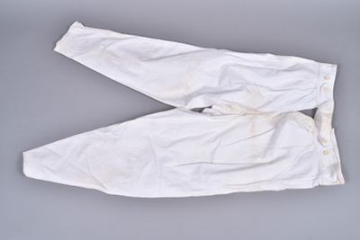 two pairs of white pants on a gray surface