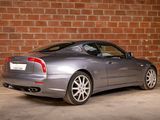 a picture of a silver sports car parked in front of a brick wall