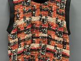 an orange and black tweed vest with black leather trim