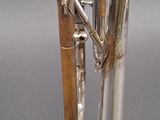 a silver trumpet with a clock on top of it
