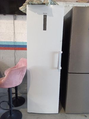 un réfrigérateur blanc et une chaise rose dans une cuisine