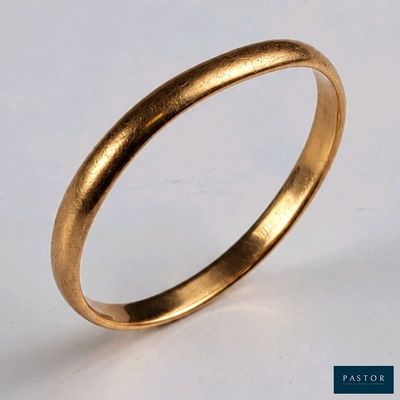 gros plan d'une bague en or sur une surface blanche