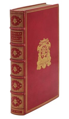 un livre rouge avec des bordures dorées et un emblème doré sur la couverture