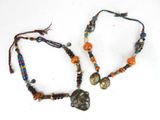 paire de colliers en perles avec un pendentif en forme de crâne attaché à un cordon