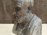 statue of a man with a beard and a mustache on a wooden table
