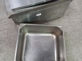 a metal pan with a handle next to a metal pan