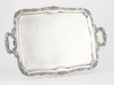 un plateau ancien en argent avec des poignées et des anses sur fond blanc