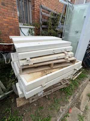 a pile of wood sitting in front of a brick building