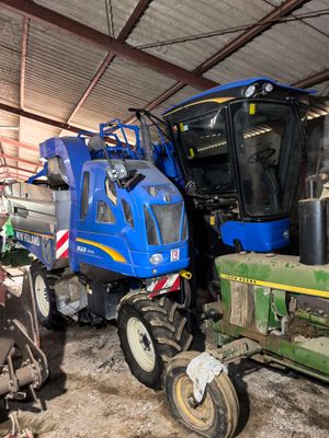 a blue tractor and a green tractor in a barn